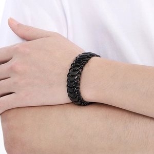 Detailed view of men's black stainless steel dragon bone chain bracelet on wrist