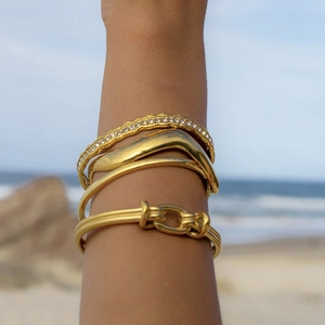 Set collana con ciondolo a stella marina e perla con bracciale dorato in spiaggia