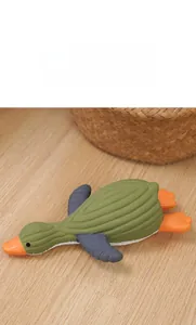 Close-up of green rubber dog toy with spiral textures on a light wood floor background