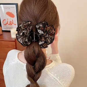 Vintage leopard print double-layered ruffle hair claw clip shown on a braided ponytail