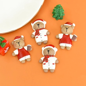 Flat lay of four resin Christmas bears in holiday outfits on an orange background