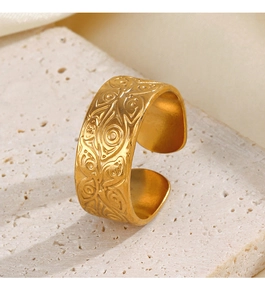 Close-up of gold vintage embossed eye pattern ring on a textured stone pedestal