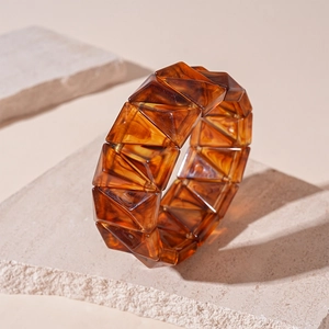 Macro shot of wide amber resin bracelet featuring geometric blocks and tortoise texture