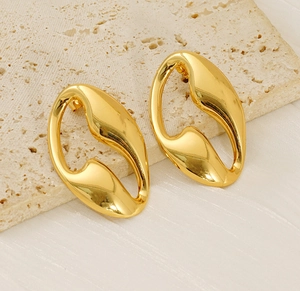 Detailed view of irregular fluid hollow earrings with glossy gold metallic finish