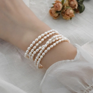 Detailed close-up of a five-layer baroque freshwater rice pearl bracelet on a wrist