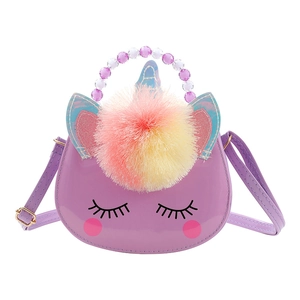 Detail of purple unicorn kids bag with plush pompom, laser ears, and beaded handle