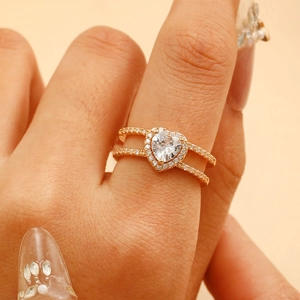 Detail of rose gold double band ring with heart zirconia worn on a finger
