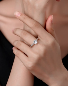 Detail of a sparkling one-carat moissanite ring in S925 sterling silver on a finger