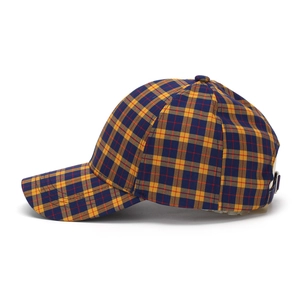 Detail of yellow and blue plaid baseball cap showing fabric texture and metal buckle