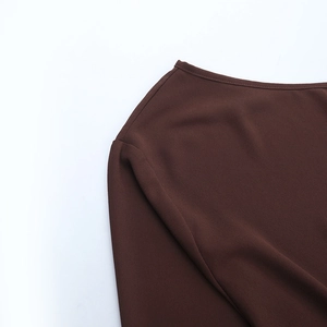 Detaillierte Makroansicht der Nähte an der Schulter dieses dunkelbraunen Chiffon-Tops