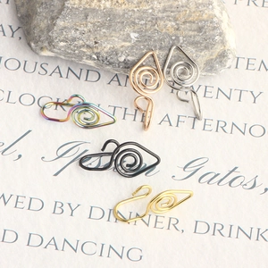 Close-up of five colorful spiral faux nose rings on artistic paper background