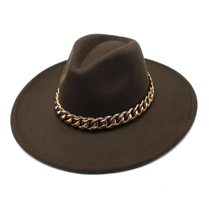 Detail of dark brown wool fedora hat featuring a bold gold metal chain decoration