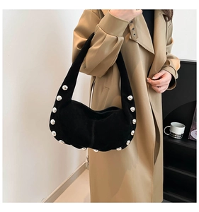 Dettaglio borsa hobo nera con grandi borchie argento e finitura in pelle scamosciata
