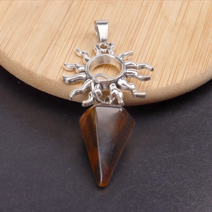 Detalle de gancho solar de metal plateado con colgante de piedra de ojo de tigre marrón cónico