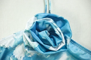 Detail of blue and white tie-dye 3D rose fabric applique on elegant halter dress