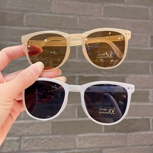 Detail of foldable kids sunglasses with UV 400 protection in beige and white frames