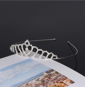 Detailed view of a silver rhinestone bridal tiara crown resting on a postcard