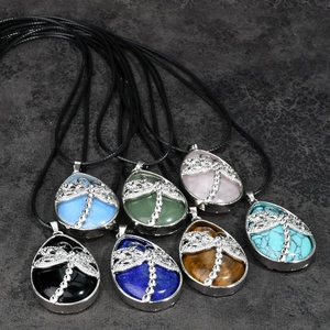 Flat lay of teardrop gemstone necklaces with dragonfly silver charms and black cords
