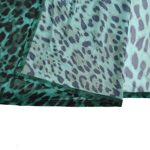 Détail macro du tissu mousseline à imprimé léopard vert avec coutures de qualité