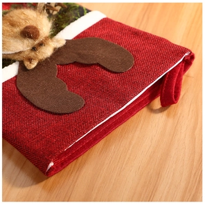 Macro shot of red burlap Christmas stocking with plush reindeer and fuzzy white cuff