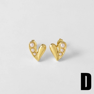 Detailed macro view of heart-shaped gold earrings with three pearls inlay design