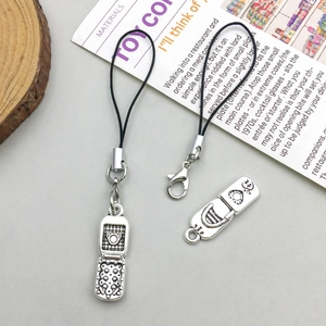 Close-up of retro silver flip phone pendant with bear cutout and black lobster clasp cord