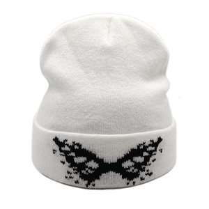 White knitted beanie with black butterfly pattern in a streetwear style on white background