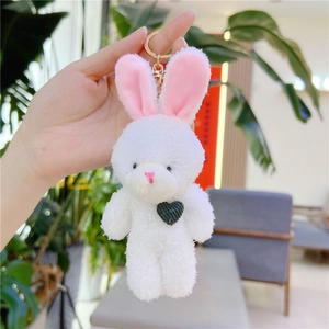 Gros plan d'un porte-clés lapin en peluche blanche avec cœur gris et fermoir doré chic