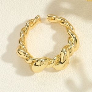 Detailed macro view of gold-plated twisted rope texture on an adjustable open ring