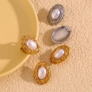 Detail of vintage oval faux pearl earrings with wheat pattern texture in gold and silver