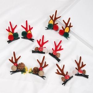 Barrettes bois de renne de Noël avec pommes de pin et champignons sur tissu blanc