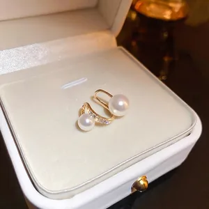 Elegant gold plated twisted pearl earrings with zircon stones on white leather box