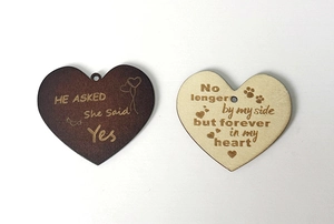 Detail of heart-shaped wooden memorial plaques with engraved marriage and pet quotes