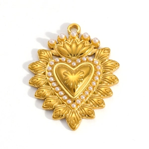 Detail of a 18k gold heart pendant with radial flame design and pearl border