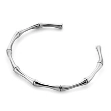 Detailed view of silver bamboo-style open cuff bracelet in polished stainless steel
