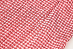 Detailed close-up of red and white seersucker fabric with checkered pattern and texture