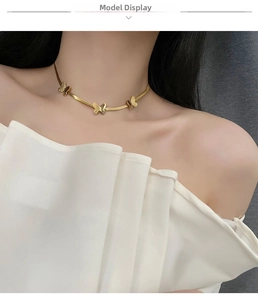 Vue détaillée d'un collier papillon doré avec chaîne serpent porté par un mannequin