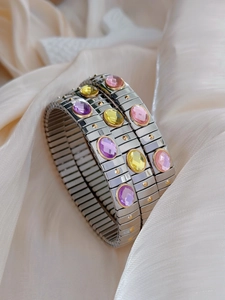 Close-up of three modular stretch bracelets with pink, yellow and purple oval crystals