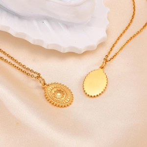 Detailed view of vintage oval medal pendants on champagne satin with gold relief pattern