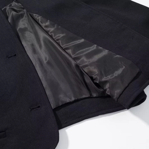 Detailed macro view of black wool coat fabric texture and glossy inner lining craftsmanship