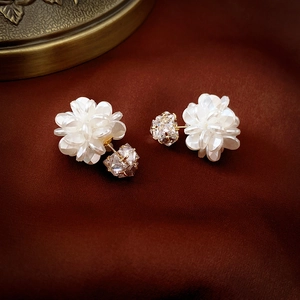 Detailed close-up of sweet white acrylic flower stud earrings with zircon crystal drops