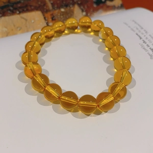 Macro shot of translucent yellow citrine crystal beads on a minimalist elastic bracelet