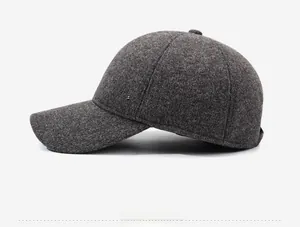 Detail of dark gray wool blend baseball cap showing thick texture and silver metal logo