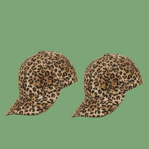Fashionable leopard print baseball caps with curved brims on a green background