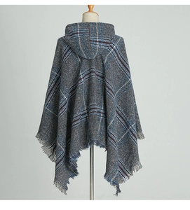 Vue détaillée du poncho à carreaux bleus avec capuche et franges sur le bord inférieur