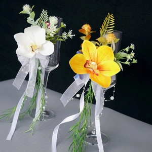 Elegant white cymbidium orchid decoration for wedding wine glasses with ribbons and pearls