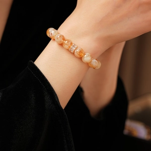 Vue détaillée du bracelet en perles ambrées avec un insert en zircon doré au poignet