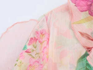Detailed macro view of pink floral print on poplin fabric with precise overlock stitching