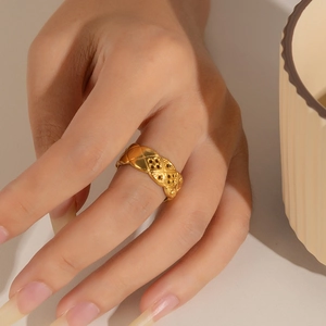 Detail of 18k gold plated stainless steel ring with quilted relief pattern on finger