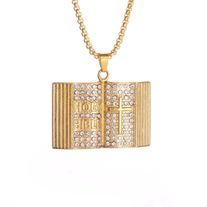 Macro shot of gold plated holy bible book pendant with sparkling crystals and box chain